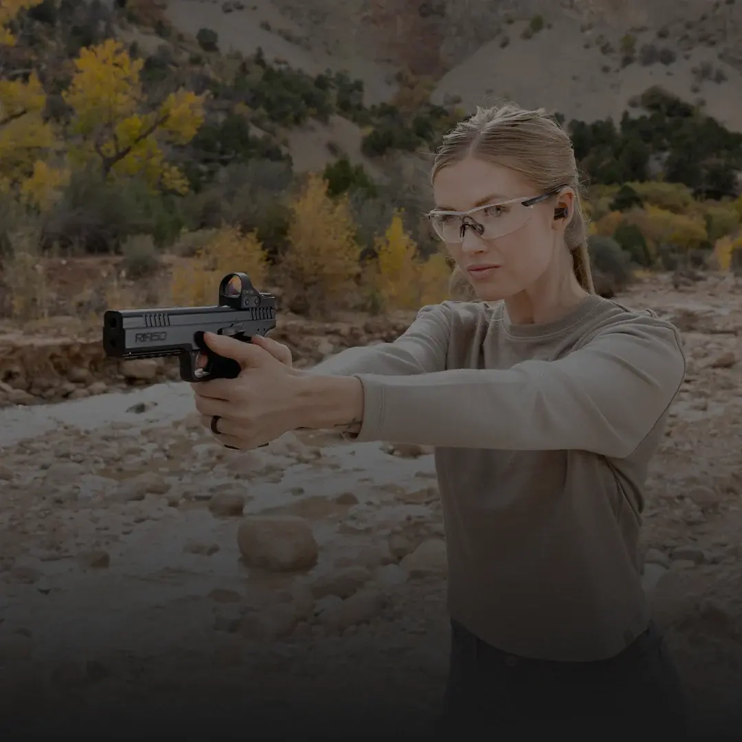 woman shooting a RIA50 at a range, dark overlay